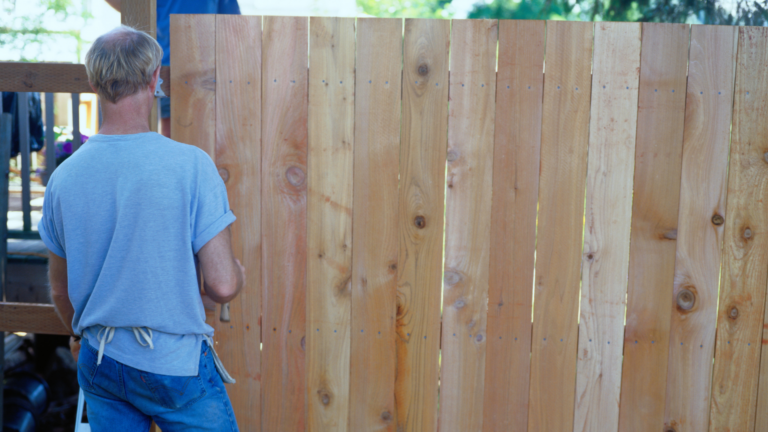 Should I install a wood fence myself or hire a professional